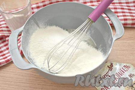 В получившуюся смесь добавляем разрыхлитель, в 2-3 захода просеиваем пшеничную муку, сразу вмешивая её венчиком.