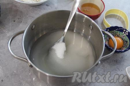 Взять глубокую кастрюлю (в процессе варки будет добавляться сода и масса сильно увеличится в объёме, поэтому и нужно сразу готовить в глубокой кастрюле). Влить в эту кастрюлю воду, всыпать сахар, перемешать и поставить на огонь.