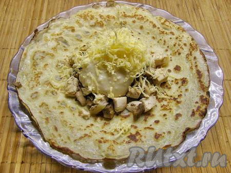 На начинку кладём 1-1,5 столовых ложки соуса. Сверху кладём натёртый сыр.