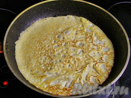 Переворачиваем блин на другую сторону и жарим его ещё 1-2 минуты. Готовый блинчик перекладываем на тарелку. Перед тем как налить следующую порцию теста, сковородку нужно смазать небольшим количеством растительного масла.