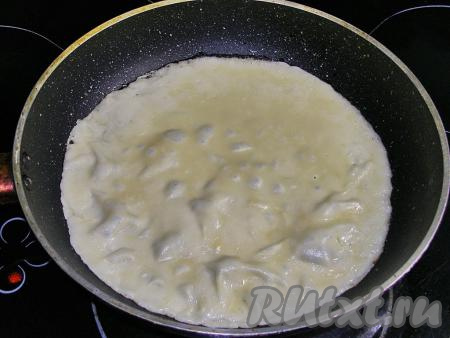 Сковородку для этих блинов нужно взять диаметром 20-22 сантиметра. Наливаем в сковороду немного растительного масла и сильно нагреваем. В горячую сковородку вливаем половник теста, наклоняем сковороду, чтобы тесто равномерно распределилось по дну. Жарим блинчик на среднем огне примерно 1-2 минуты. Готовый блин подрумянится и будет легко отставать от сковороды.