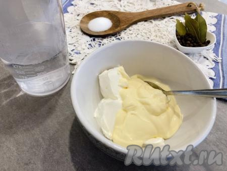 Пока обжаривается лук, в отдельной ёмкости смешиваем 3 столовых ложки сметаны и 3 столовых ложки майонеза (при желании майонез можно заменить на сметану), вливаем 200 миллилитров воды комнатной температуры, ещё раз перемешиваем и заливка готова.