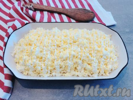 Вторым слоем равномерно раскладываем натёртые яйца, сверху рисуем сеточку из майонеза.