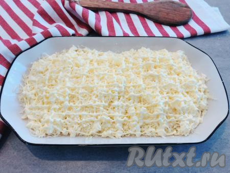 Салат будем выкладывать на блюдо для подачи слоями. Первым слоем выкладываем натёртые плавленные сырки, сверху равномерно распределяем чеснок. Поверх чеснока наносим сеточку из майонеза.