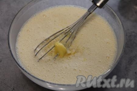 Растопить сливочное масло до жидкого состояния. Растопленное не горячее масло влить в тесто, перемешать венчиком. Блинное тесто получится не густым и однородным.