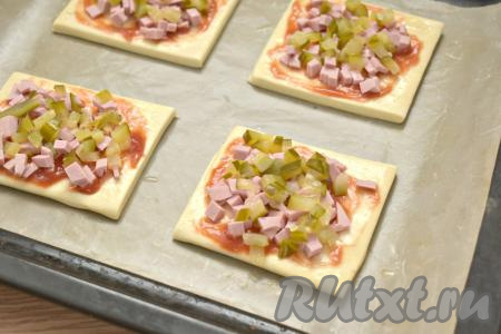 Огурцы нарезаем на маленькие кубики. Раскладываем часть нарезанных огурцов поверх колбасы.