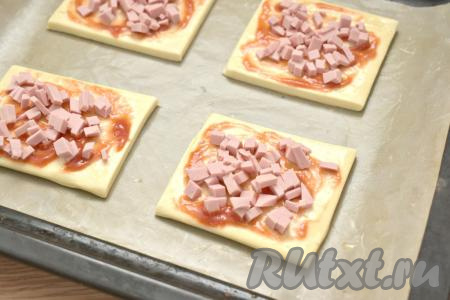 Колбасу нарезаем на маленькие кубики, размещаем ровным слоем на тесто. Раскладывая начинку для мини-пицц (колбасу, овощи и сыр), учитывайте, что из двух слоёв теста мы будем формировать 8 мини-пицц и начинку соответственно нужно делить на 8 равных частей.