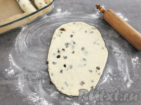 Рабочую поверхность присыпаем мукой, чтобы избежать прилипания теста. Берём одну часть теста и при помощи рук круговыми движениями как бы растягиваем тесто в стороны, придавая форму круглой лепёшки, а затем скалкой раскатываем тесто в длинный пласт.