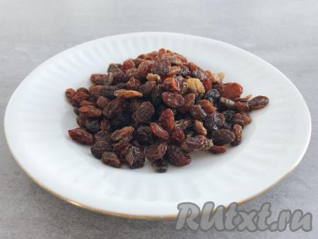 Перебираем изюм, удаляем плодоножки (если они есть), промываем его тёплой водой. Если изюм жестковат, заливаем его кипятком и оставляем минут на 5, после этого лишнюю воду сливаем. Затем подготовленный изюм выкладываем на полотенце (или салфетку) и даём обсохнуть.