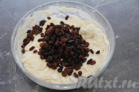 Перемешать тесто ложкой, а затем вымесить руками. Если тесто будет очень липнуть, смажьте руки маслом, но старайтесь не добавлять лишнюю муку. Добавить изюм в тесто.