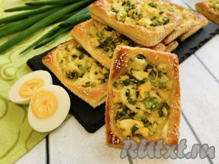 Ароматные, хрустящие, аппетитные слойки с яйцом и зелёным луком достать из духовки, дать немного остыть, переложить на блюдо и подать вкусную выпечку к столу!