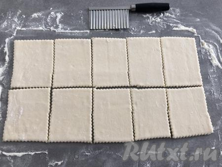 Нарезать тесто на прямоугольники размером приблизительно 10х6 сантиметров. У меня получилось 10 штук. Нарезала я фигурным ножом для сыра, чтобы получились ажурные края. Вы можете нарезать тесто обычным ножом.