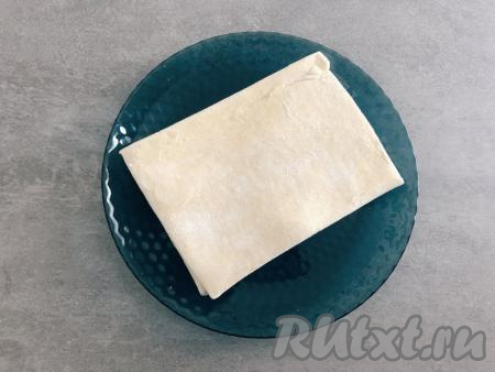 Замороженное дрожжевое слоёное тесто достать из морозилки и разморозить его при комнатной температуре.&nbsp;