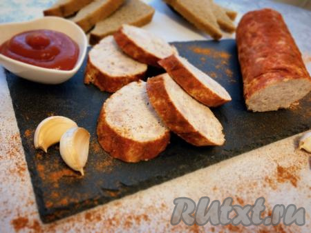 По окончании времени приготовления достаём домашнюю колбасу из духовки, даём остыть, снимаем рукав для запекания. Нарезаем колбасу порционно и подаём к столу.