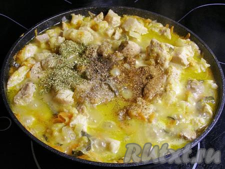 Вливаем в сковородку воду (или бульон) комнатной температуры, добавляем соль, приправы и специи на свой вкус. Я добавила адыгейскую соль, чёрный свежемолотый перец, приправу для мяса и сушёную зелень. Перемешиваем, даём воде закипеть, уменьшаем огонь до минимального и тушим свинину с солёными огурцами, луком и морковкой под закрытой крышкой минут 20 (до мягкости мяса).