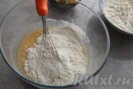 Добавить в миску соль. Муку просеять и начать небольшими частями всыпать в миску, перемешивая тесто для кулича вначале венчиком.