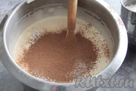 Во взбитую яичную массу всыпать какао и разрыхлитель, небольшими частями начать добавлять просеянную муку, перемешивая тесто лопаткой. Добавляя муку, учитывайте, что бисквитное тесто должно получиться очень воздушным, в меру густым, напоминающим сметану средней жирности.