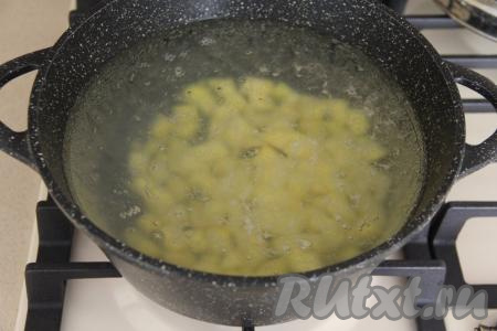 Влить 2 литра воды в кастрюлю, поставить на огонь. В закипевшую воду выложить очищенную и нарезанную на средние кубики картошку.