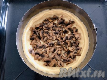 Половину обжаренных грибов выкладываем на тесто и равномерно распределяем.