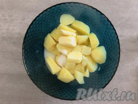 В первую очередь займёмся приготовлением картофельной основы для пирога. Для этого очищенный картофель кладём в кастрюлю (если картошины крупные, их можно разрезать на несколько частей), заливаем полностью холодной водой, ставим на огонь и отвариваем до полной готовности (минут 20-25 с момента закипания воды). Затем воду сливаем, к картофелю добавляем сливочное масло и тёплое молоко, солим по вкусу (я добавила 1 чайную ложку соли), разминаем при помощи толкушки до получения однородного пюре.