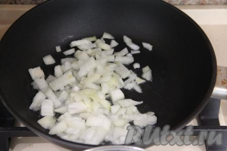 В сковороду влить растительное масло, разогреть, после этого добавить мелко нарезанный лук и обжаривать его на среднем огне, помешивая, до золотистого цвета (в течение 6-7 минут).
