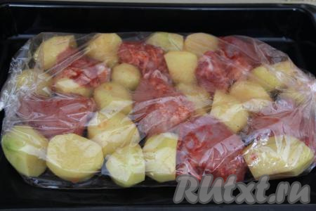 Рукав для запекания выложить на противень и в него поместить курицу с картошкой. Завязать рукав с двух сторон. Сделать поверх рукава пару проколов зубочисткой для выхода пара.