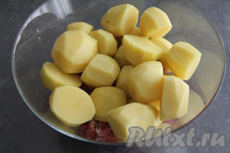 Нарезать очищенный картофель на крупные дольки. У меня были картошины среднего размера и я просто разрезала их пополам. Выложить картошку к курице, влить растительное масло и хорошо перемешать.