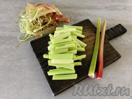 Стебли ревеня моем, обсушиваем, при помощи острого ножа снимаем кожицу. Затем каждый стебель нарезаем поперёк на полоски длиной 4-5 сантиметров. Слишком толстые стебли дополнительно разрезаем вдоль.