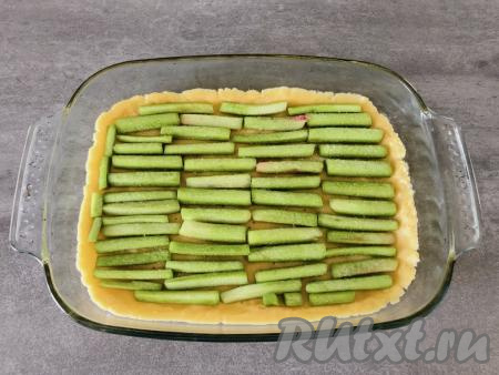 Стебли ревеня откидываем на дуршлаг, чтобы избавиться от сока, который они выделили, а затем раскладываем их поверх теста. Те кто любят послаще, могут дополнительно посыпать стебли 1-2 чайными ложками сахара. Ставим запекать в разогретую до 180 градусов духовку на 20 минут.