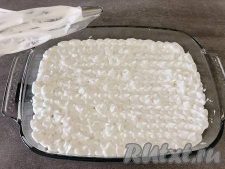 Через 20 минут достаём пирог из духовки и при помощи силиконовой лопатки выкладываем на него взбитые белки, равномерно распределяя и разравнивая их по всей поверхности пирога. Вы можете также использовать кондитерский мешок и отсадить безе красивыми шапочками, как это сделала я.