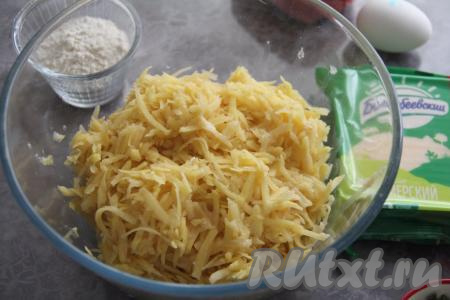 700 грамм очищенного картофеля натереть на крупной тёрке, отжать выделившийся сок (картофельный сок нам не понадобится). Получившуюся картофельную массу переложить в объёмную миску.