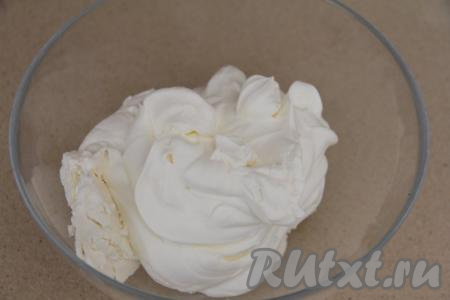 Сливки для приготовления крем-чиза должны быть очень холодными, переложить их в ёмкость, удобную для взбивания. Всыпать к сливкам 2 столовых ложки сахарной пудры и взбить на высоких оборотах миксера до мягких пиков, после этого добавить творожный сыр.