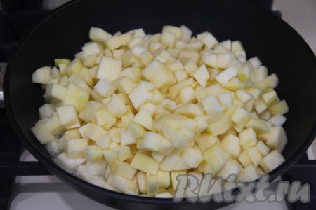 Яблоки почистить, срезая кожуру и удаляя семечки, затем нарезать на мелкие кубики, выложить в сковороду, посыпать 30 граммами сахара, полить 20 миллилитрами лимонного сока, перемешать и поставить на средний огонь. 