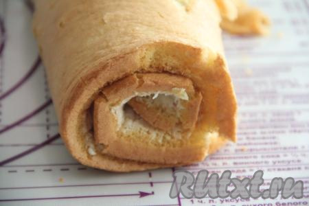 Свернуть бисквит с крем-чизом в плотный рулет, начиная с широкой стороны. Завернуть рулет в пергамент и отправить в холодильник на ночь для стабилизации.