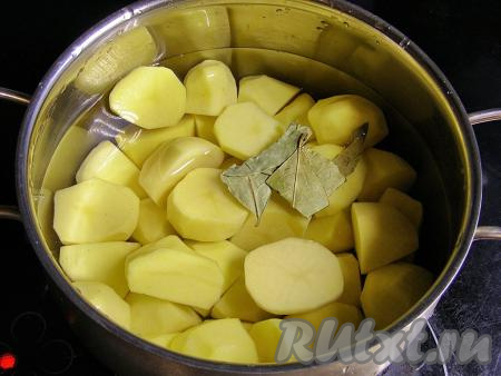 Картофель моем, очищаем от кожуры и кладём в кастрюлю (крупные клубни можно разрезать на 2-4 части), заливаем полностью холодной водой, солим по вкусу, добавляем лавровые листья и ставим на сильный огонь. Доводим до кипения, затем варим картошины на небольшом огне минут 20-25 (до готовности). Готовый картофель должен легко прокалываться ножом.