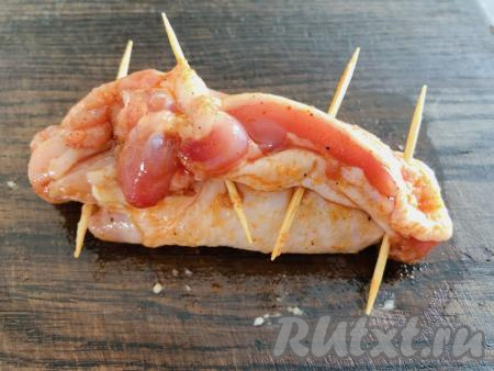 Сворачиваем филе с сыром, начиная с широкой стороны, в рулет. Края рулета скрепляем зубочистками.