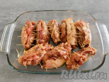 Сформированные рулеты из куриных бёдрышек выкладываем в форму для запекания. Форму перед выкладыванием рулетиков смазывать маслом не нужно, так как растительное масло входит в состав смеси, которую мы наносили на мясо.&nbsp;Рулеты отправляем запекаться в разогретую до 190 градусов духовку на 50 минут.