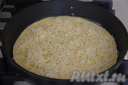 Диаметр сковороды, на которой вы будете жарить тортилью, должен быть чуть больше диаметра тортильи. Смазать сковороду растительным маслом и поставить на медленный огонь. Выложить лепёшку на сковороду, присыпать половиной натёртого сыра.&nbsp;