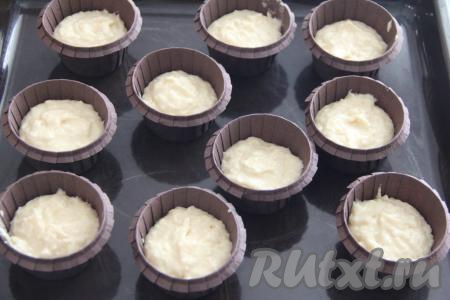 Разложить тесто по формочкам для выпечки маффинов, заполняя их чуть больше, чем на половину объёма. У меня были бумажные формы, их, также как и силиконовые формочки, смазывать маслом нет необходимости. Если у вас железные формы, тогда их следует обязательно предварительно смазать маслом. Всего у меня получилось 10 заготовок маффинов.