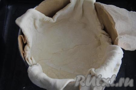 Круглую форму для выпечки (я взяла форму диаметром 18 сантиметров) застелить пергаментом, затем выложить слоёное тесто, сформировать бортики. 