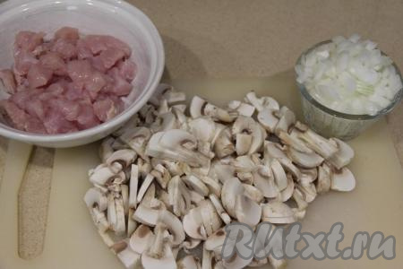Шампиньоны и куриное филе промыть водой. Нарезать шампиньоны на пластинки. Лук почистить и мелко нарезать. Куриное филе нарезать на кусочки размером 1 сантиметр на 1 сантиметр.