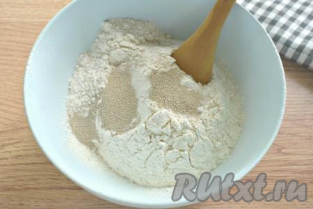 В глубокую миску просеиваем пшеничную муку. Всыпаем к муке соль и сухие быстродействующие дрожжи, перемешиваем, образуя в центре углубление.