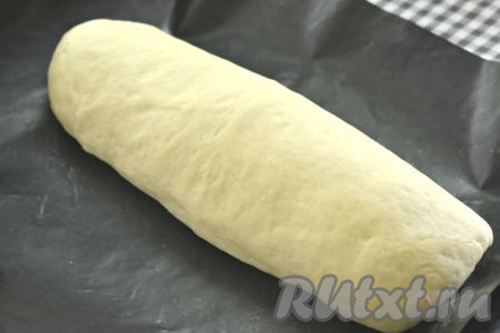 Рулет сразу выкладываем швом вниз на противень, заранее застеленный ковриком (или бумагой) для выпечки. Накрываем заготовку молочного батона полотенцем и оставляем для расстойки минут на 30-40.