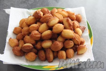 Готовые пончики выкладывать на бумажное полотенце. Постепенно пожарить все пончики из оставшегося теста. Вот такая гора пончиков из сгущёнки получилась.