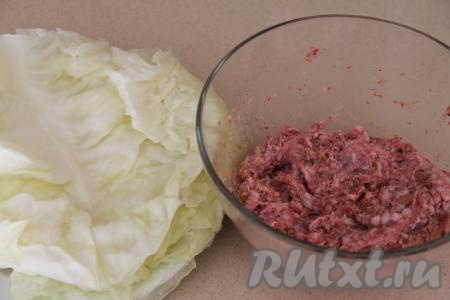 Из кочана капусты вырезать кочерыжку. Для того чтобы листья были эластичными, их можно размягчить в микроволновке или в кастрюле. Я размягчила в микроволновке, для этого нужно завернуть кочан в пищевую плёнку и отправить в микроволновку минут на 8-10 при максимальной мощности, затем развернуть плёнку и снять размягчившиеся листья (в этот раз у меня листья капусты стали мягкими за 10 минут, но многое зависит от сорта капусты). У меня капустные листья были крупными, поэтому я взяла с кочана 7 листьев, а затем разрезала листья по середине (вдоль утолщенной части), в результате я сформировала 13 голубцов. Если листочки у капусты небольшие, можно взять и 13 листьев для формирования голубцов. Если не хотите размягчать листья в микроволновке, тогда можно поместить кочан в кастрюлю, залить его полностью водой, поставить на огонь, после закипания на небольшом огне проварить 4-5 минут, достать кочан, аккуратно отделить мягкие листья, затем кочан с оставшимися листочками снова поместить в эту же кастрюлю и продолжать варить ещё несколько минут (до мягкости листьев). Дать листьям остыть.