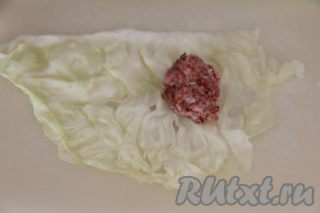 Теперь можно приступать к формированию голубцов, для этого нужно взять лист капусты, у основания листа выложить часть начинки из фарша и гречки, а затем завернуть её в капустный лист конвертиком (то есть накрыть вначале начинку ближайшей частью листа, после этого подвернуть на начинку длинные боковые края листа и свернуть лист рулетиком, начиная с края с начинкой). У меня получилось 13 голубцов среднего размера.