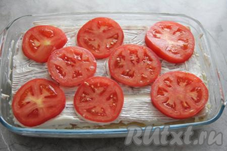 Помидоры нарезать на кружочки и выложить поверх рыбы.