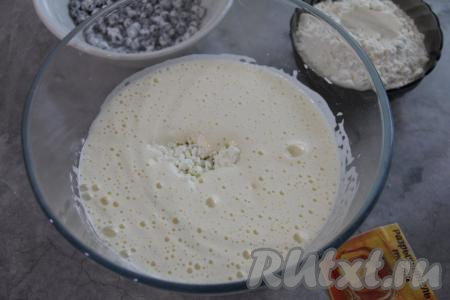К яйцам, взбитым с сахаром, влить растительное масло, перемешать лопаткой. Добавить творог, снова перемешать лопаткой.
