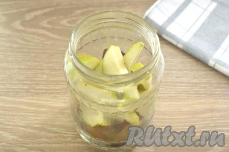 Половинки слив и ломтики груш перекладываем в подготовленную банку.