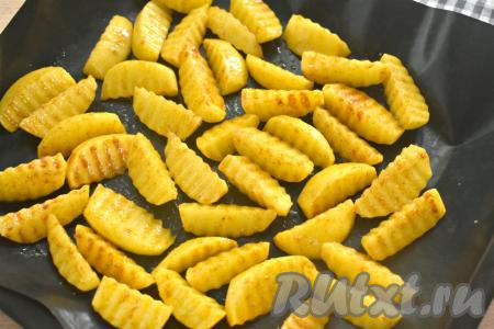 Застилаем противень ковриком для выпечки (или фольгой, или пергаментом), затем выкладываем картофель в один слой и отправляем в духовку, разогретую до 190 градусов.